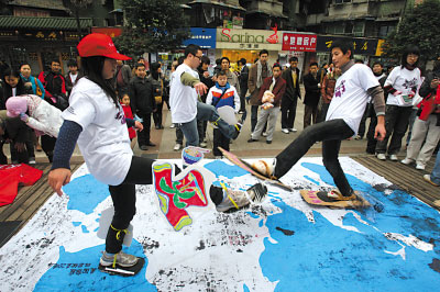 【重庆商报】大学生行为艺术宣传环保：碳足迹留白布